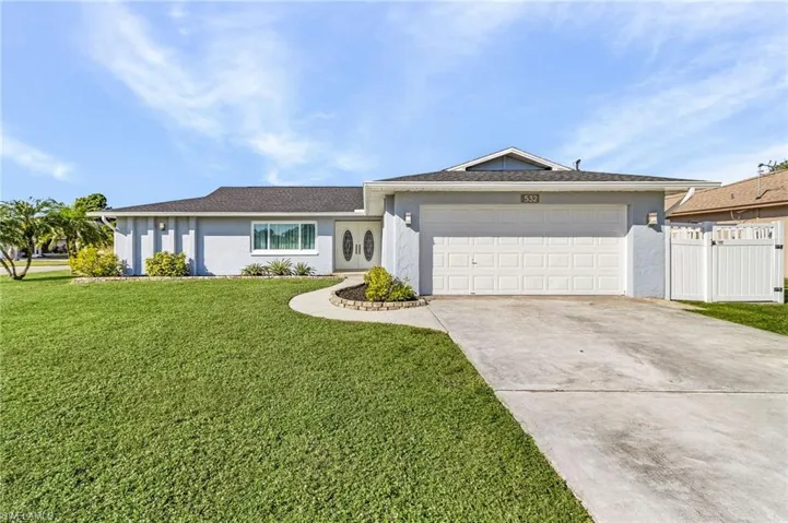 Ranch-style house featuring a front lawn and a garage