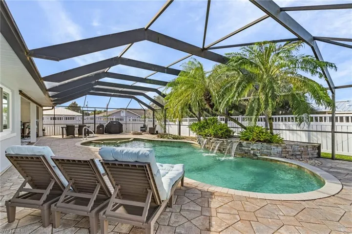 View of swimming pool with a lanai, a patio area, and pool water feature