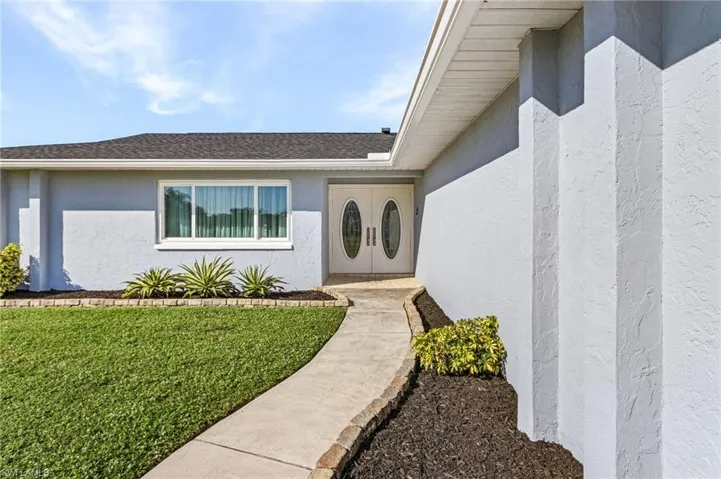Doorway to property featuring a yard