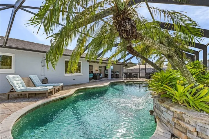 View of swimming pool featuring a lanai, a patio area, and pool water feature