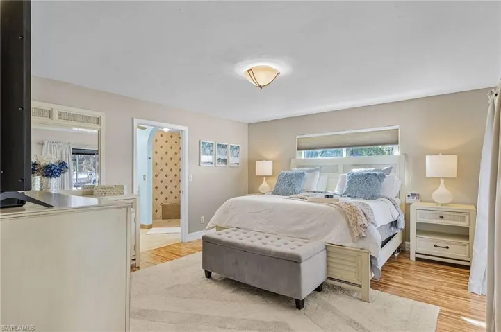 Bedroom with light hardwood / wood-style floors and connected bathroom
