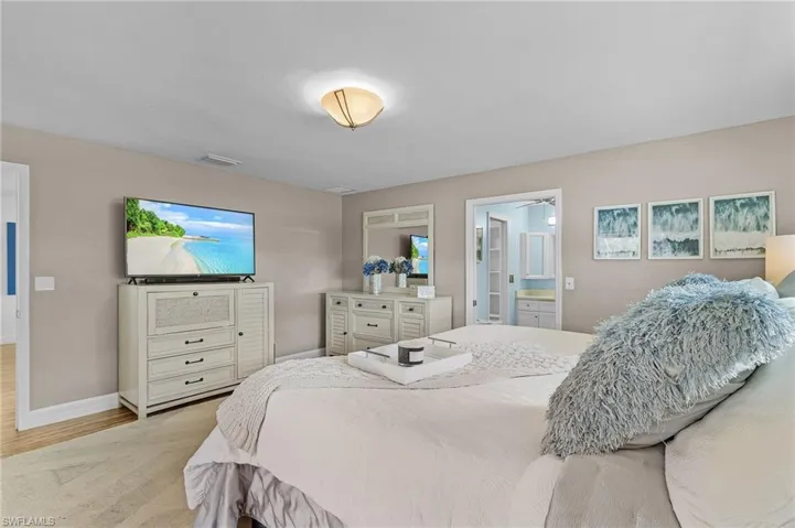 Bedroom featuring ensuite bath and light wood-type flooring