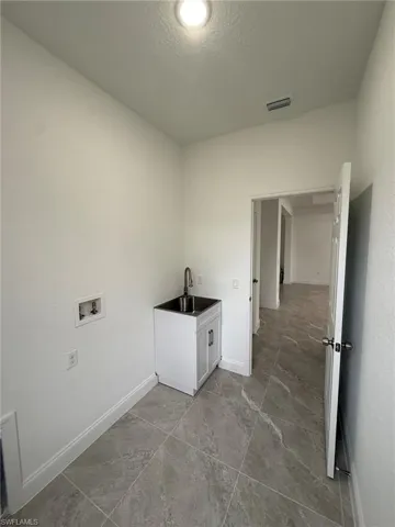 Laundry room with a textured ceiling and hookup for a washing machine