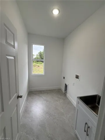 Laundry room featuring hookup for a washing machine, a textured wall, hookup for an electric dryer, and a textured ceiling
