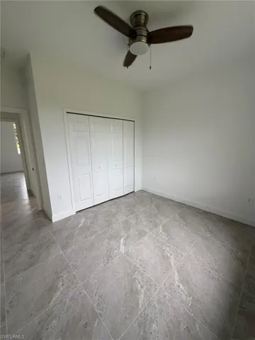 Unfurnished bedroom featuring a closet and ceiling fan