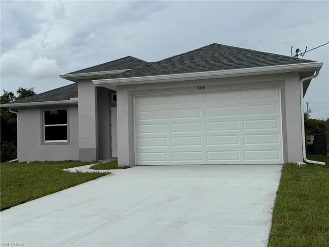 Ranch-style house with stucco siding, roof with shingles, concrete driveway, and a front yard