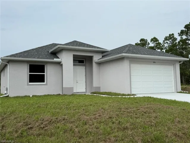 View of front of house featuring an attached garage, a front yard, a shingled roof, and stucco siding