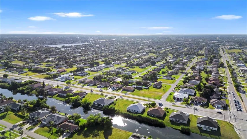 Aerial perspective of suburban area featuring a nearby body of water
