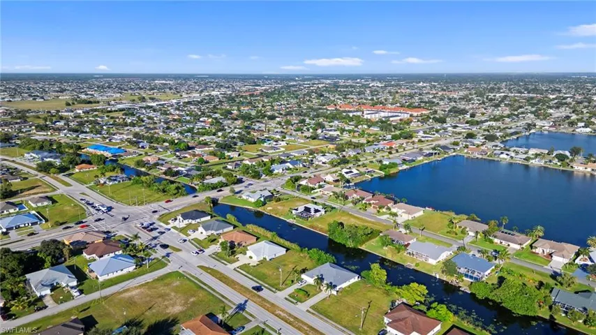 Aerial view of property and surrounding area with a nearby body of water and nearby suburban area