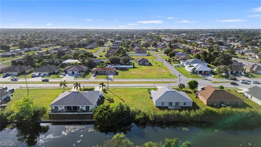 Aerial perspective of suburban area featuring a nearby body of water