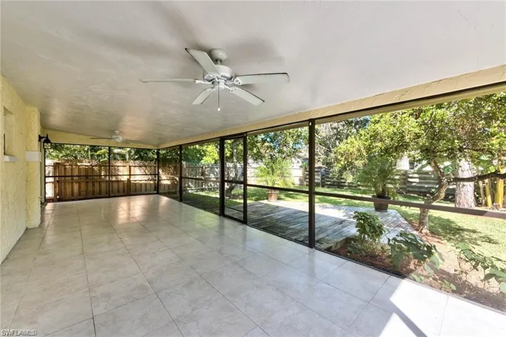 Unfurnished sunroom featuring ceiling fan