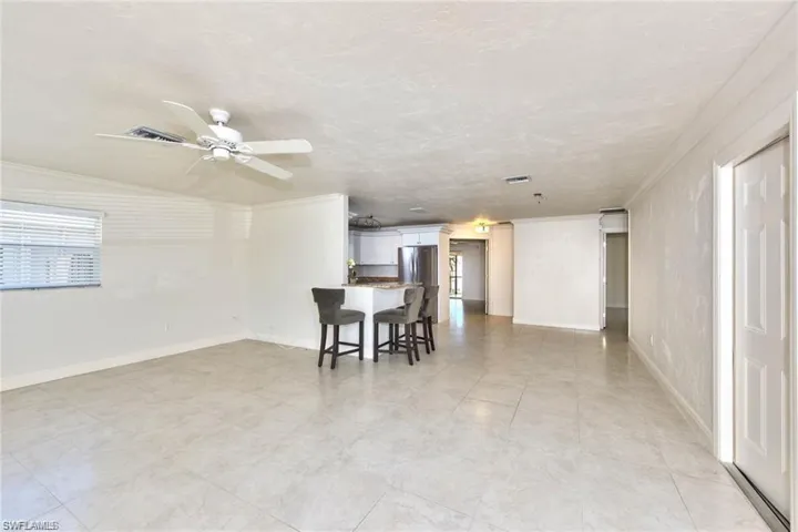 Dining room featuring visible vents, baseboards, crown molding, and a ceiling fan