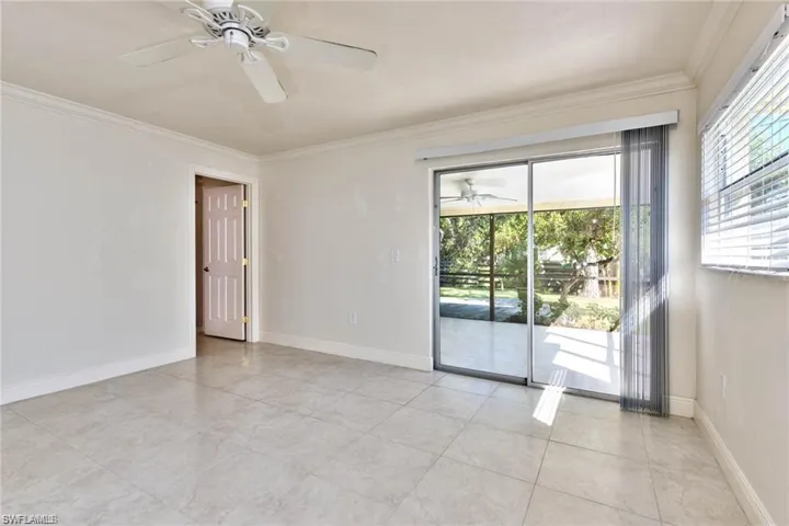 Spare room with a ceiling fan, baseboards, and ornamental molding
