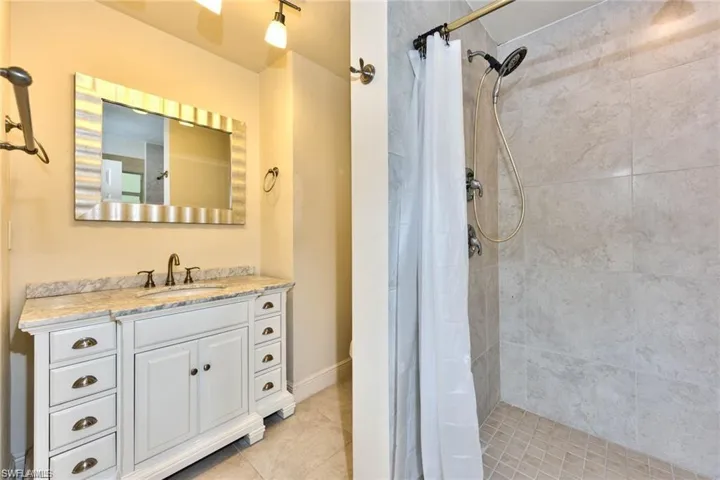 Full bath featuring vanity and a tile shower