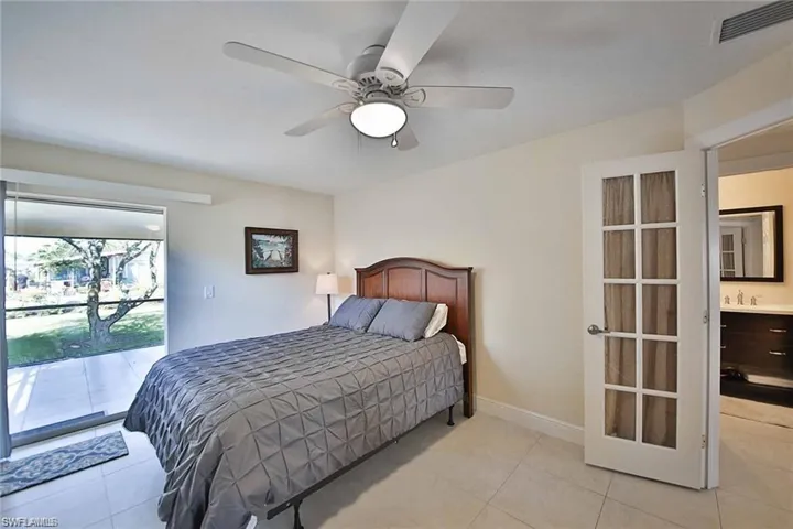 Bedroom with visible vents, baseboards, access to outside, light tile patterned flooring, and a sink