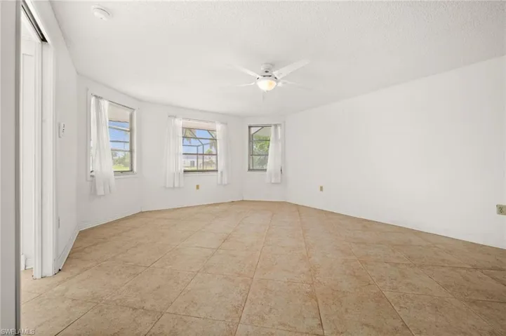 Primary bedroom with a walk in closet and view of the pool