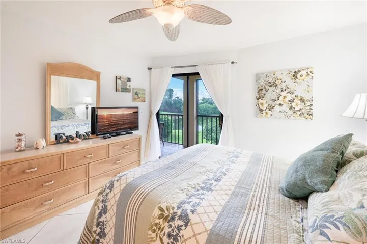 Bedroom featuring access to outside, light tile patterned floors, and a ceiling fan