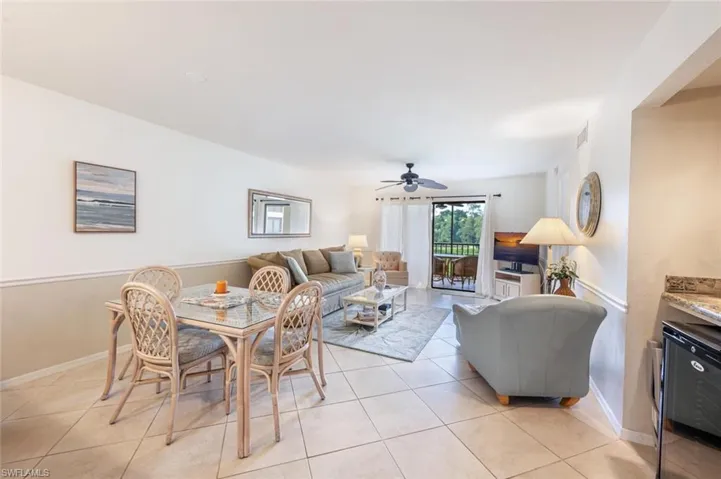 Living area featuring light tile patterned floors and ceiling fan