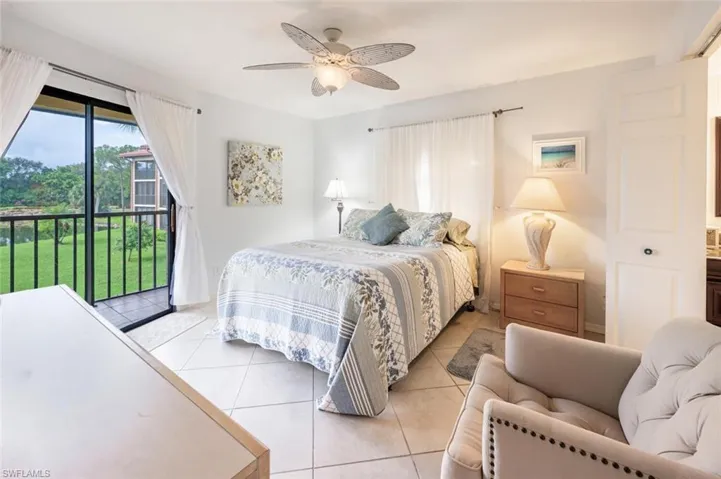 Bedroom featuring access to outside, light tile patterned flooring, and a ceiling fan