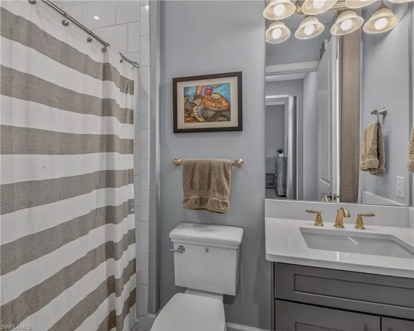Bedroom with access to exterior, a raised ceiling, ceiling fan, ornamental molding, and light wood-type flooring