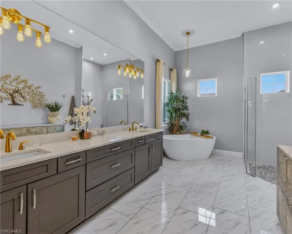 Bathroom with walk in shower, ornamental molding, a freestanding bath, double vanity, and recessed lighting