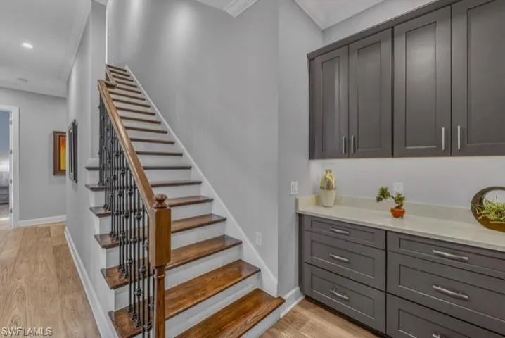 Office space featuring light wood-style flooring, crown molding, and ceiling fan