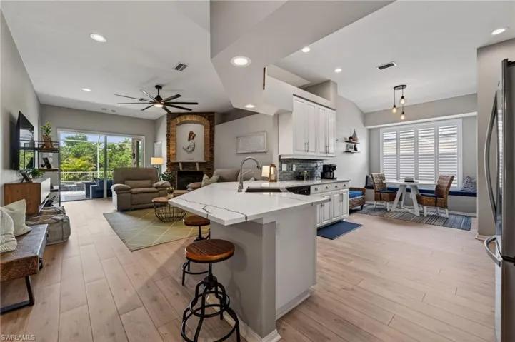 Kitchen with a peninsula, a breakfast bar area, open floor plan, and white cabinets
