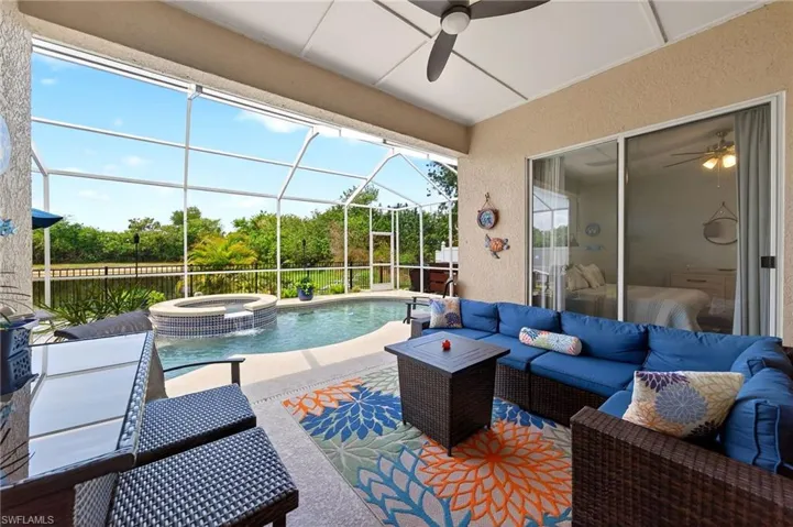 View of patio / terrace featuring a sunroom, an outdoor lounge area, a pool with connected hot tub, ceiling fan, and glass enclosure