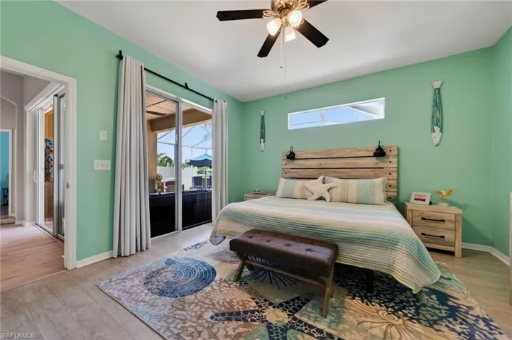 Bedroom with light wood-style floors, access to outside, and a ceiling fan