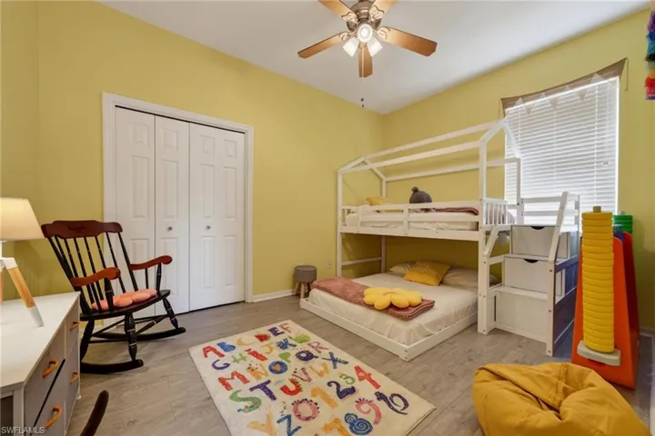 Bedroom featuring light wood-style floors, ceiling fan, and a closet
