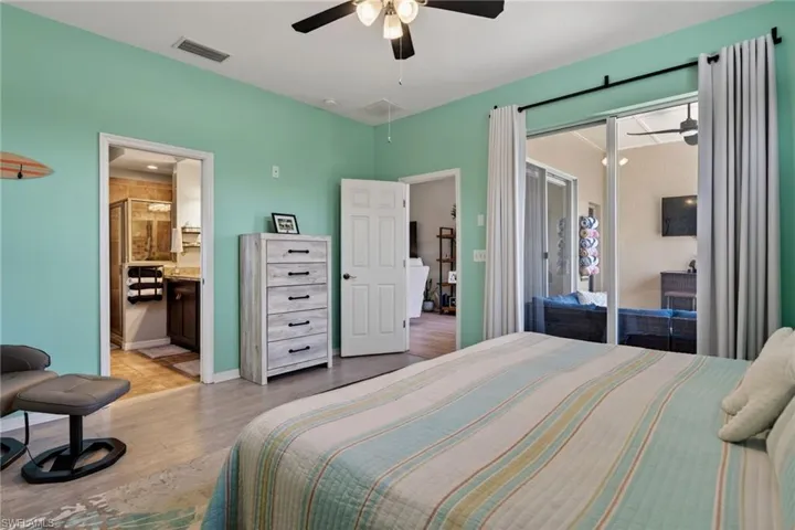Bedroom with access to exterior, light wood finished floors, and ceiling fan