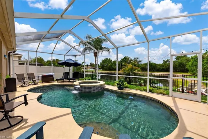 Relaxing pool / spa featuring glass enclosure, a sunroom, and a patio area