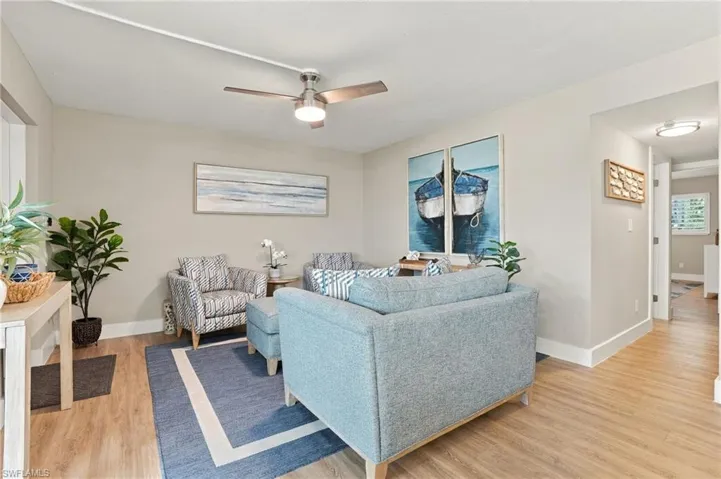 Wood-finish flooring, neutral wall tones, and a brushed nickel ceiling fan with integrated lighting