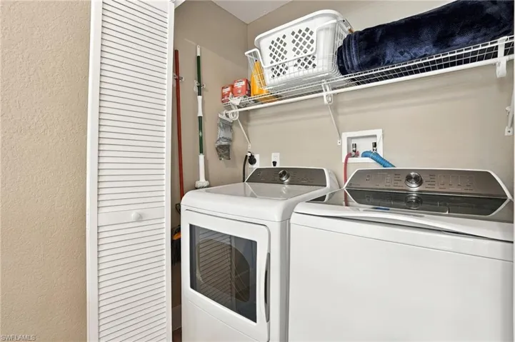 Laundry area featuring built-in louvered-door cabinetry and integrated wire shelving
