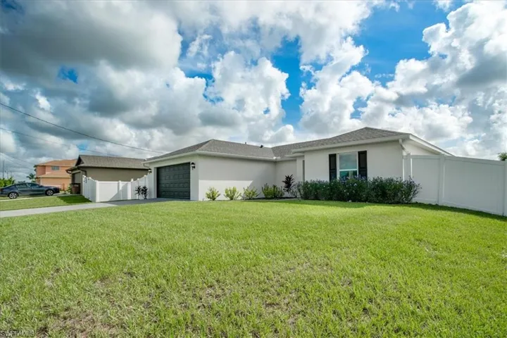 Single story home featuring a garage and a front yard