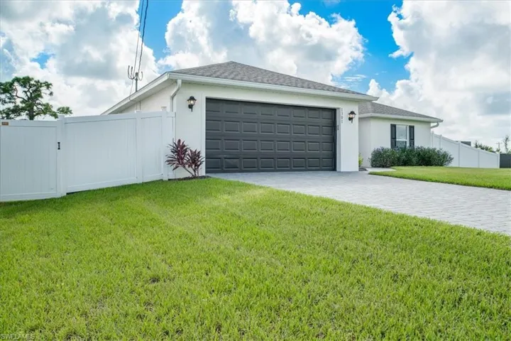 View of front of property featuring a front yard and a garage
