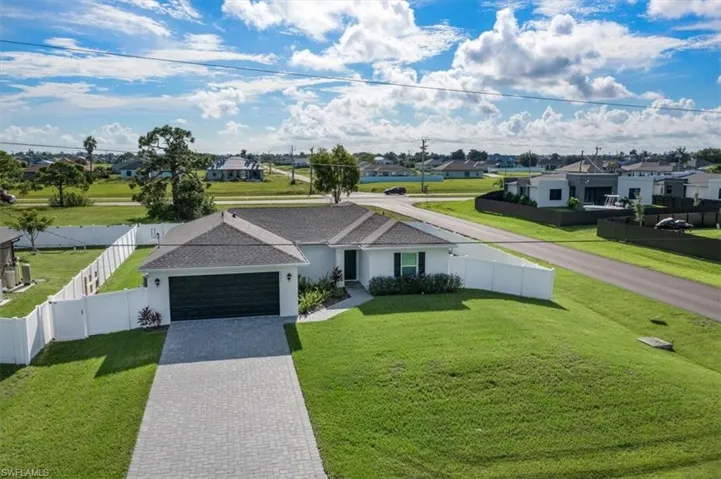 Ranch-style home featuring a garage and a front lawn