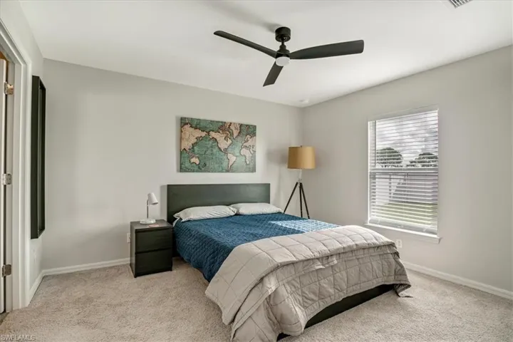 Bedroom with ceiling fan and light carpet