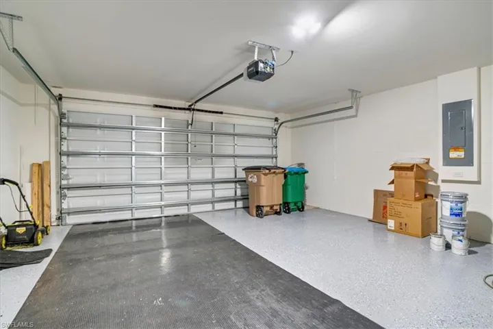 Garage featuring a garage door opener and electric panel