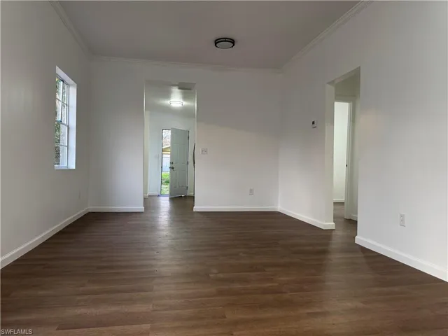 Unfurnished room featuring dark wood finished floors and crown molding