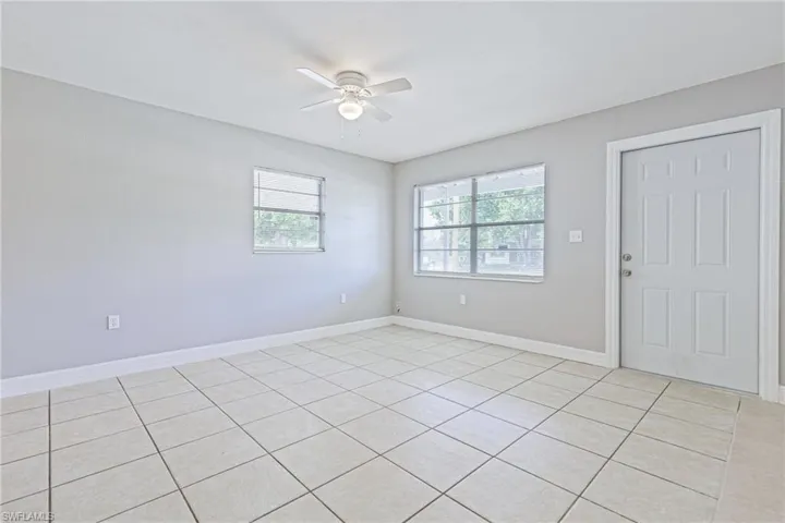 Tiled spare room featuring ceiling fan