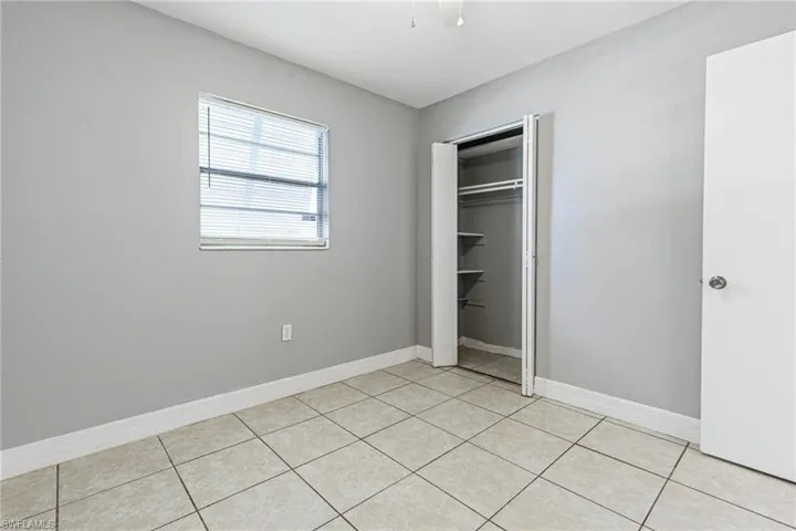 Unfurnished bedroom featuring a closet and light tile floors