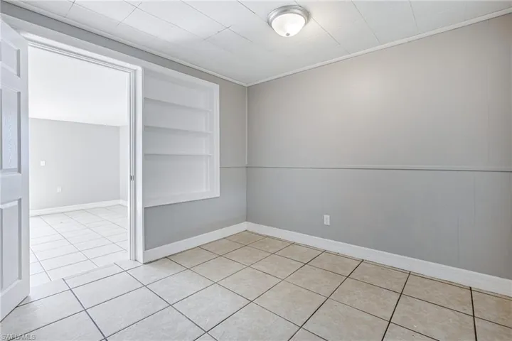 Tiled empty room with built in shelves