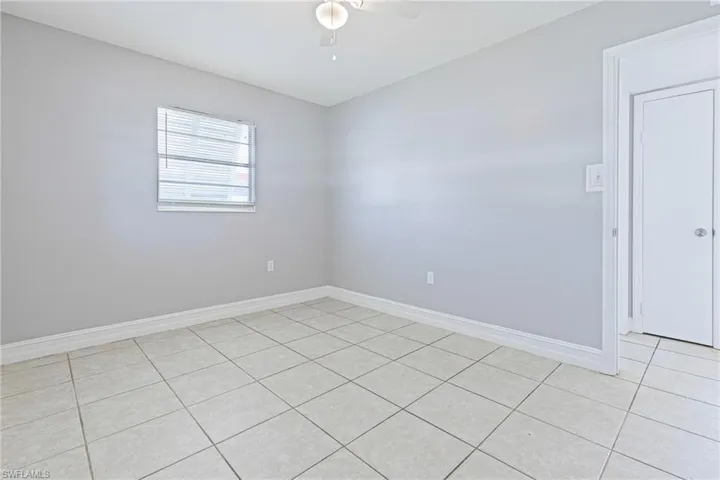 Tiled empty room featuring ceiling fan