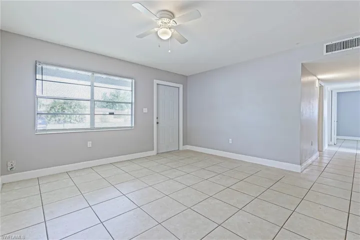 Tiled spare room featuring ceiling fan