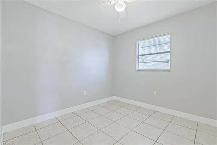 Tiled empty room with ceiling fan