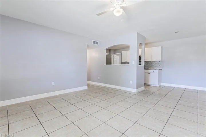 Unfurnished room with ceiling fan and light tile floors