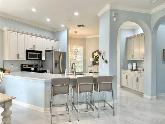Kitchen featuring appliances with stainless steel finishes, pendant lighting, tasteful backsplash, and sink