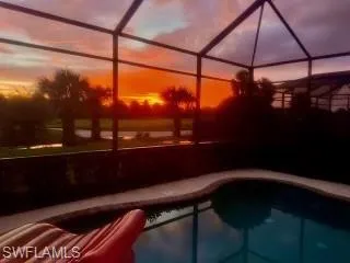 Pool at dusk featuring a lanai