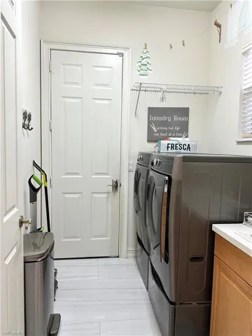 Laundry area featuring light tile patterned flooring and independent washer and dryer